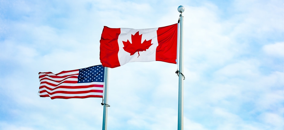 The Canadian and American flags on a summer's day