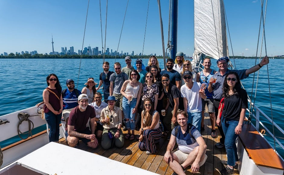 Cyclica staff on a boat on Lake Ontario, in front of the Toronto skyline.