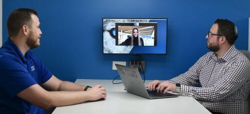 Two Arctic Wolf colleagues in an office, on a video conference with a client