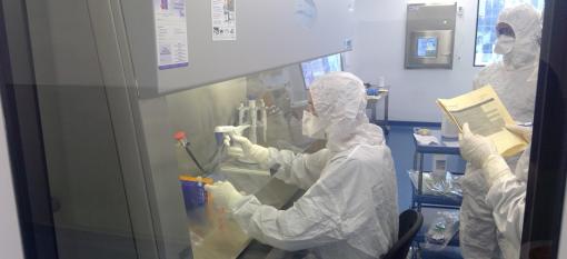 Three operators working in the cleanroom wearing cleanroom suits