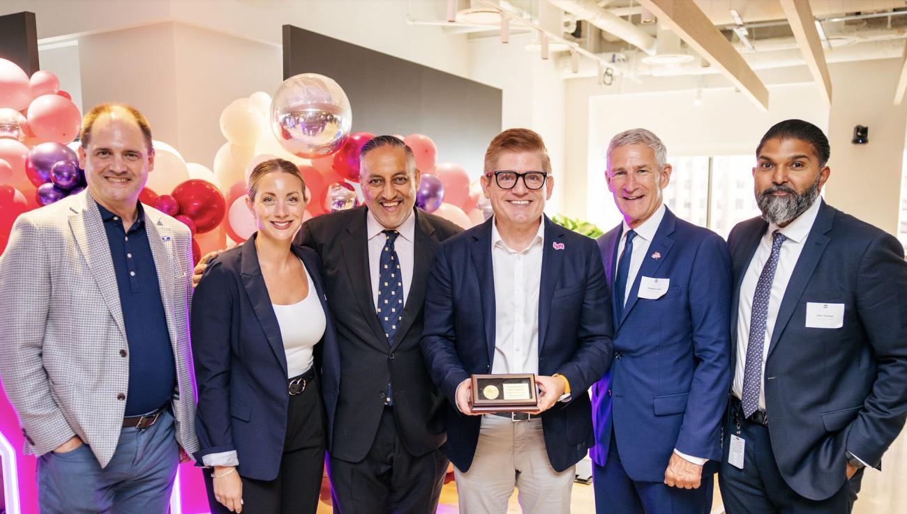 Des représentants d’Investissement Ontario et de la Ville de Toronto remettent une pièce commémorative de félicitations au chef des politiques publiques de Lyft.